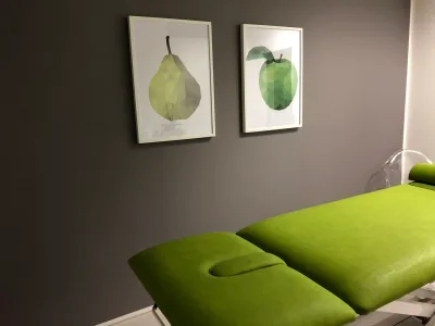 Heller Behandlungsraum mit grüner Therapieliege bei physio mölmsch in Mülheim an der Ruhr